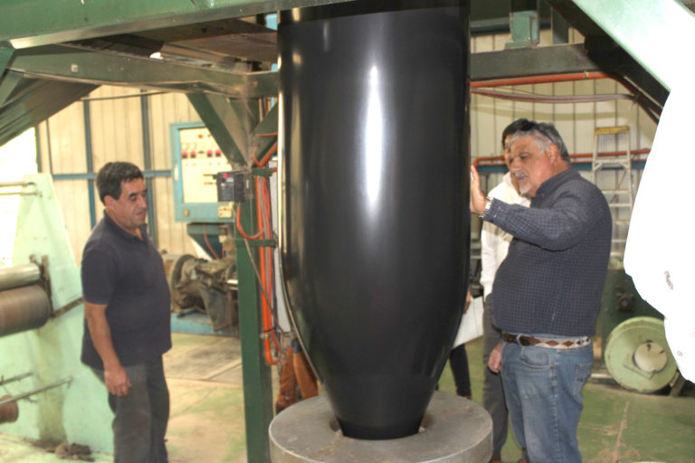 El empresario ovallino, Bruno Eccher, mostrando el proceso de fabricación de las bolsas plásticas dentro de la planta, luego de la fase de reciclaje de la materia prima.