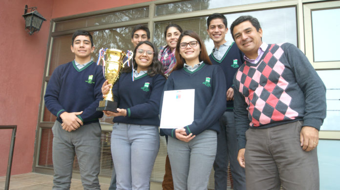 Los estudiantes lucen la copa y el diploma de ganadores regionales de debate de inglés.