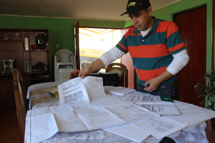 Aldo Gallardo, presidente de la asociación muestra los planos y las escrituras que acreditarían que los terrenos pertenecen al Comité Villa Minera El Despertar, y no a la junta de vecinos.