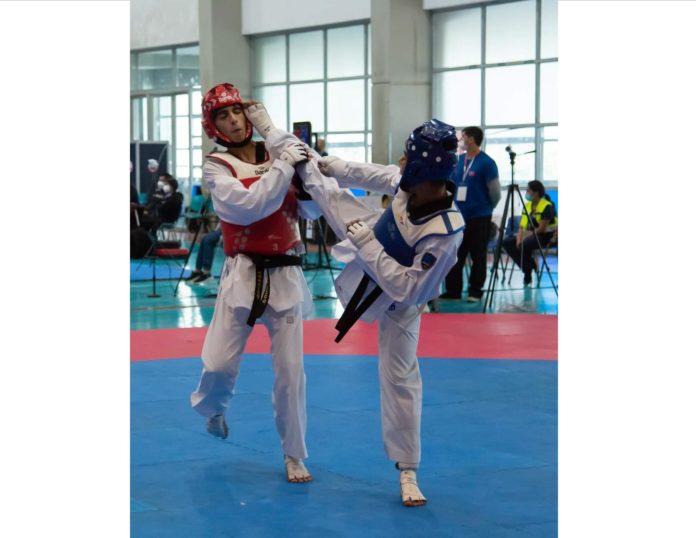 Kevin Contreras (cabezal azul) en uno de sus combates de la Copa Chile de Taekwondo.